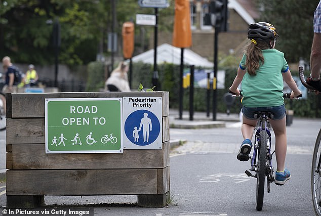 A young cyclist passes by the barriers in a low-traffic neighbourhood
