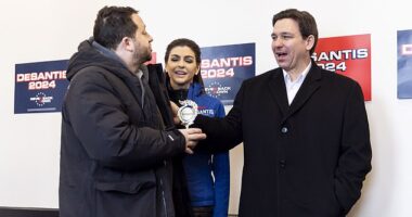 Florida Gov. Ron DeSantis and wife Casey dismiss political comedian Davram Stiefle as he interrupted a press conference to present the 2024 hopeful with a 'participation trophy' at a campaign stop in Atlantic, Iowa on Saturday