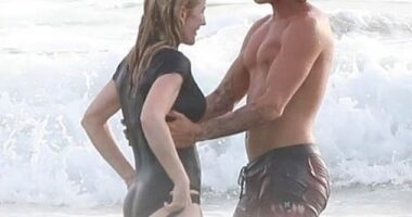 Handsome surfing instructor Armando Perez holds a smiling Ellie close as the waves roll in