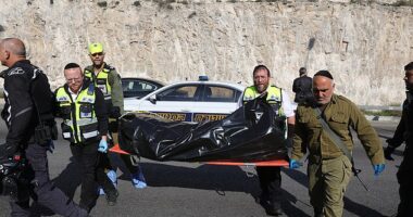 One person has been killed and seven more wounded by gunmen who opened fire in the West Bank today, Israeli police have said. Pictured: Israeli emergency services lift a body sealed in a bag on a stretcher from the scene near Jerusalem, February 22