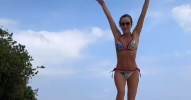 Amanda Holden, 53, showcased her washboard abs in a tropical print bikini as she teased her swimwear drop while holidaying in the Maldives on Tuesday