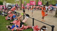 London Marathon runners stretch out as they recover from taking part in the world famous event