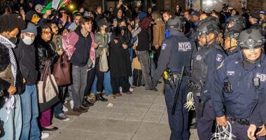 NYPD officers face protestors after detaining demonstrators and clearing an encampment set up by pro-Palestinian students and protesters on the campus of New York University