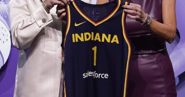 Caitlin Clark posing for a photo with WNBA commissioner Cathy Engelbert after being selected first overall by the Indiana Fever in the first round of the WNBA draft on Monday