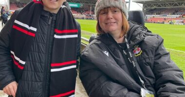 Wrexham fan Theo Smith, 10, poses with Kerry Evans, right, who established a 120-seat section at the Racecourse Ground for fans with autism and physical challenges to watch football