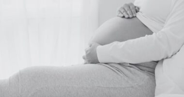 pregnant woman holding her belly black and white