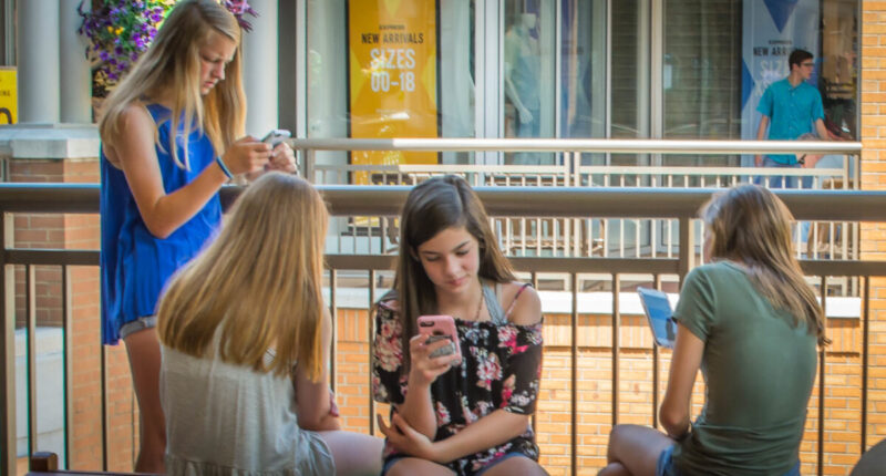 kids sitting around on their phones