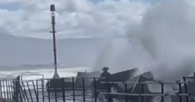 Heart-stopping footage has emerged of a dad bravely diving into rough waters to save his daughter who had been swept away by a large wave (pictured)