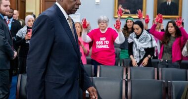 Protesters from the group Code Pink stand as U.S. Secretary of Defense Lloyd Austin arrives for a House Appropriations Committee hearing on Capitol Hill
