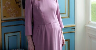 Queen Margrethe poses in one of the rooms at Fredensborg Castle, as she leans against beautifully decorated teal walls