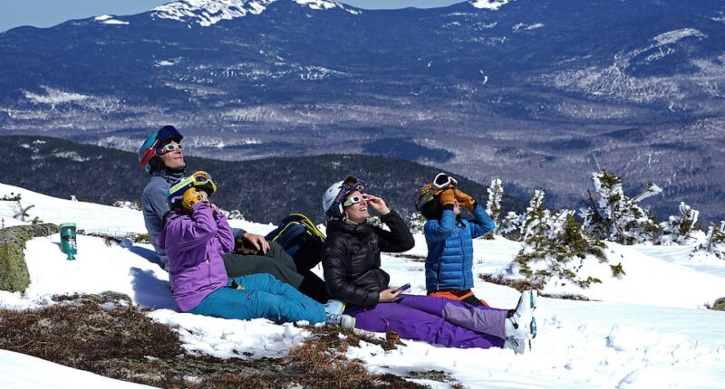 A family watches the solar eclipse from Saddleback Mountain in Rangeley, Maine, on Monday April 8th, in one of the last viewings of the day