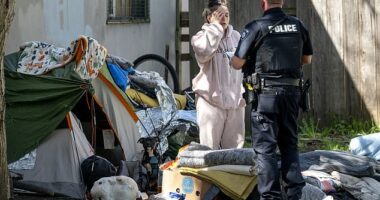 A Grants Pass, Oregon, police officer issues a citation to a homeless woman camped in a city park on Monday. The town has appealed a district court ruling that barred officials from fining locals for sleeping outside