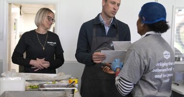 Prince William is given cards for his wife Kate and father King Charles by volunteer Rachel Candappa during a visit to Surplus to Supper in Sunbury-on-Thames, Surrey, this afternoon