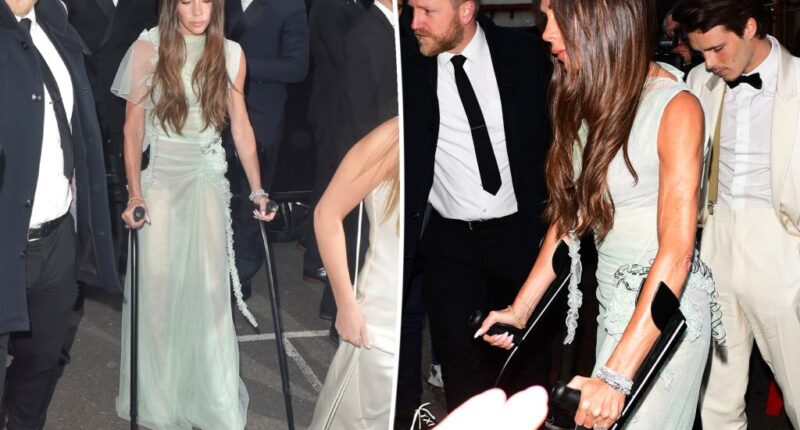 Victoria Beckham arrives at her star-studded 50th birthday party with crutches