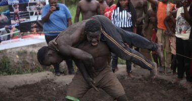 Young Ugandans tangle in the mud. They dream of becoming professional wrestlers