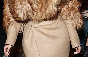 Cardi B caught the eye at McQueen's runway show as she sported a short brunette wig and a fur maxi coat as she was joined by Salma Hayek for the star-studded event on Saturday amid Paris Fashion Week