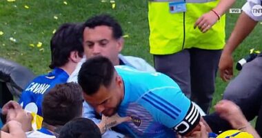 A Boca fan puts his left hand on the chest of goalkeeper Romero after losing to River Plate