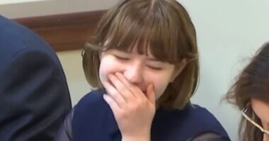 A teenage girl on trial accused of murdering her mom and attempting to kill her stepdad giggled and tried to cover her mouth as day four of proceedings got underway