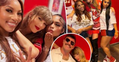 Taylor Swift poses in front of Eras Tour poster in Travis Kelce's Chiefs suite