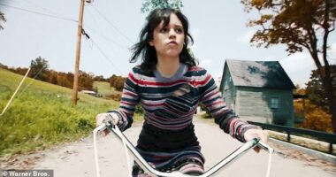 Astrid Deetz (Jenna Ortega) seen cycling through East Corinth, the location for Tim Burton's sequel to his 1988 cult classic - the tiny village also appeared in the first film