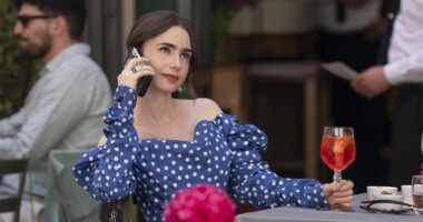 Lily Collins wearing a blue dress and talking on the phone in Emily in Paris season 4