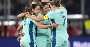Kyra Cooney-Cross (centre) is mobbed by her teammates after scoring a special goal from around 40 metres out to level the scores in Germany
