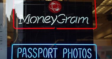 Above, neon signs for MoneyGram's transfer services at a passport photo shop in New York