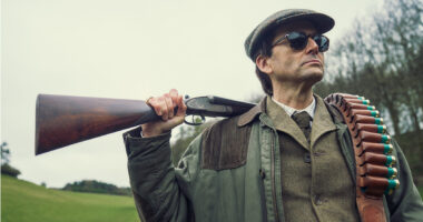 David Tennant as Lord Tony Baddingham with a shotgun and sunglasses in Rivals