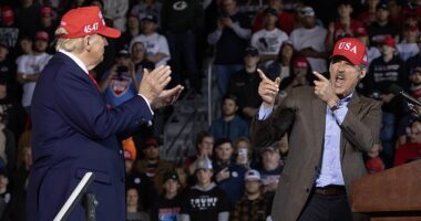 Republican presidential nominee former President Donald Trump listens as GOP candidate for U.S. Senate for Wisconsin Eric Hovde speaks during a rally at Dodge County Airport on October 06, 2024 in Juneau, Wisconsin. Cook Political Report indicated Hovde has been improving in his race