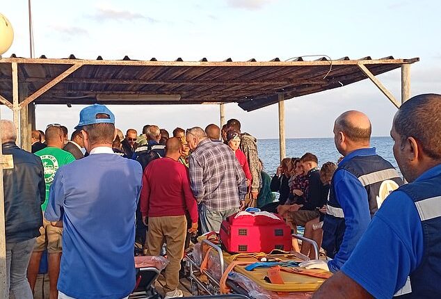 Medics and people wait for possible survivors after a boat sank at a harbour in Marsa Alam, Red Sea Governorate, in Egypt, 25 November 2024