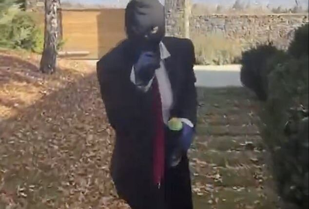 A masked vandal pictured inside the grounds of a luxury home owned by Gerard Pique