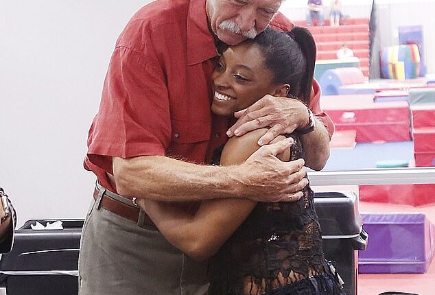 Simone Biles hugs Bela Karolyi during a 2016 opening event for the World Champions Centre