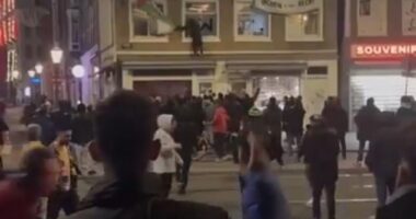 Israeli football hooligans tear down Palestine flags in Amsterdam as taxi drivers 'fight back' in night of chaos ahead of Maccabi Tel Aviv's visit to Ajax