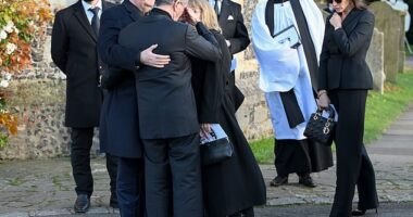 Simon Cowell is comforted by Liam Payne's father Geoff Payne (left) after the funeral today