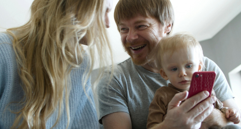 Parents with baby looking at a smart phone