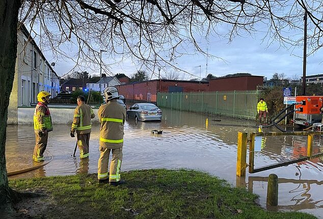 Firefighters work to pump water away from flooded residential streets near Moat Park in Dundonald on the outskirts of Belfast after Storm Bert battered the UK on Saturday