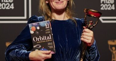 Samantha Harvey poses with the trophy and her book "Orbital" after winning the Booker Prize award 2024, in London