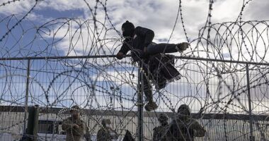 A migrant from Venezuela climbs over a border fence in an attempt to enter and seek asylum in El Paso, Texas, from Ciudad Juarez, Chihuahua, Mexico, on April 2, 2024
