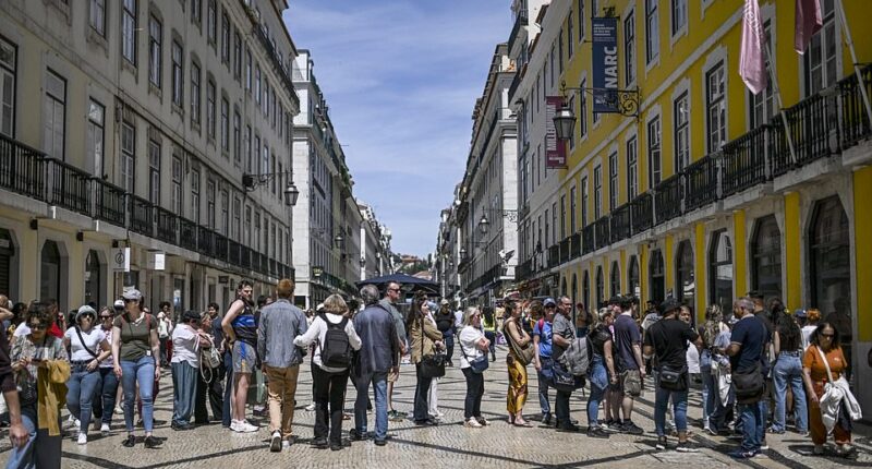 People queue for the ATM at downtown Lisbon on April 28 during a massive power cut affecting the entire Iberian peninsula