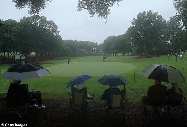Spectators sit in the rain and watch play during a practice round prior to the 2017 PGA Championship at Quail Hollow Club. Similar circumstances are impacting the event this year