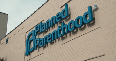 blue sign on building that reads "Planned Parenthood"