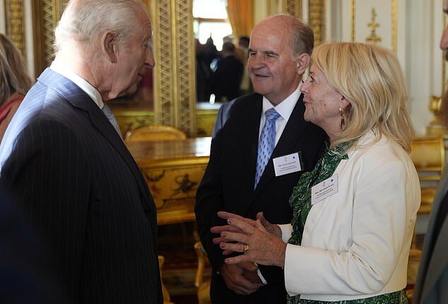 King Charles speaks with Alistair and Heather James, the parents of the late broadcaster Deborah James, during a reception in Buckingham Palace on Wednesday