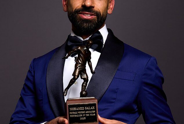 Salah was seen in a navy jacket with black lapels, a white shirt and a bow tie as he posed with the trophy