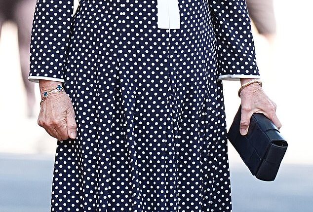 The Queen looked regal as she stepped out in an elegant polka dot monochrome Fiona Clare couture maxi dress, along with comfortable black heels and a matching clutch bag