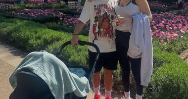 The beaming couple share a moment while taking their new baby Jagger on a walk in the sun