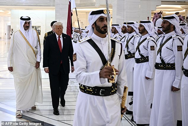 Qatar's Emir Sheikh Tamim bin Hamad al-Thani (left) and President Donald Trump review honour guards