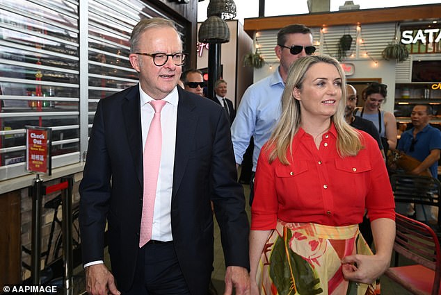 Former university protester Anthony Albanese has made reducing student debt and encouraging more Australians to buy an electric vehicle the hallmarks of his campaign (he is pictured with fiancée Jodie Haydon campaigning in Brisbane)
