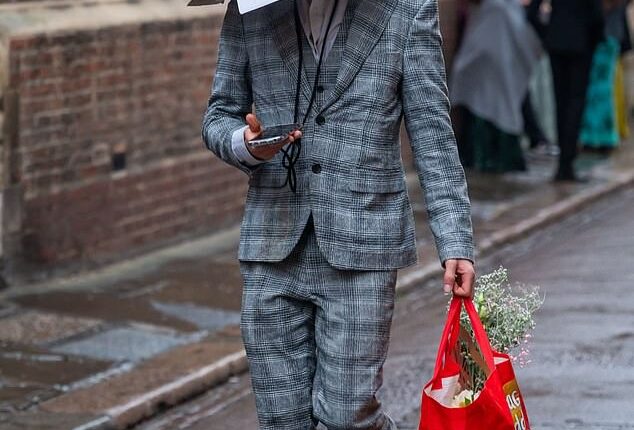 One man is pictured wearing a box over his head the morning after the Trinity Ball at Cambridge