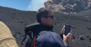 Tourists pause to snap pictures of the huge cloud of volcanic ash