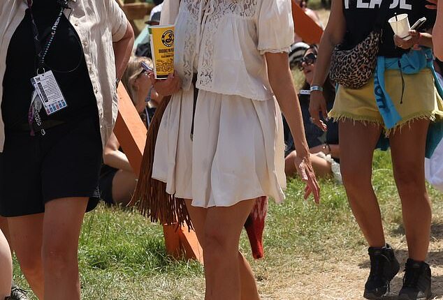 Holly Willoughby got into the festival spirit as she milled around Glastonbury with a drink in hand on Friday